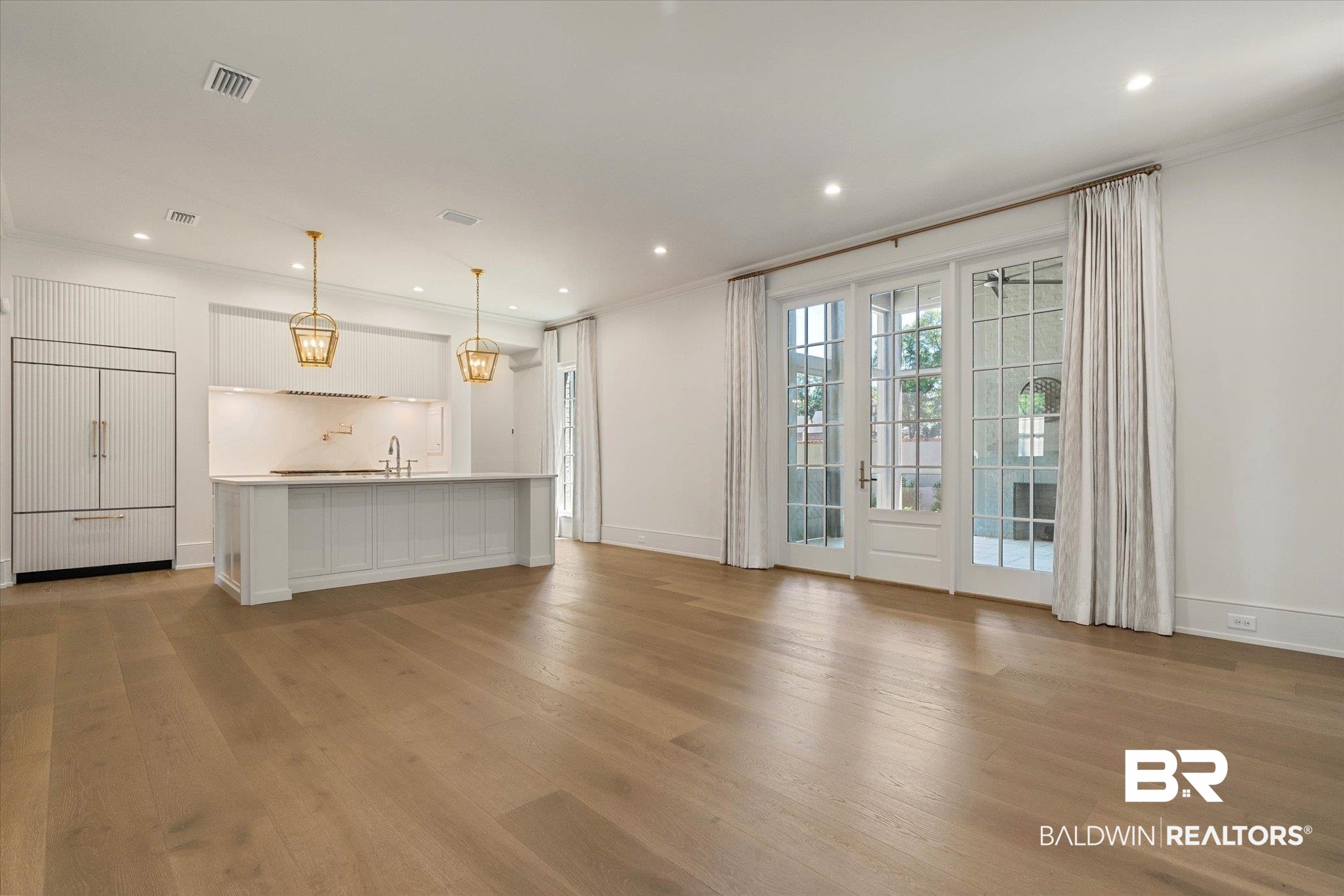 3 Canterbury Park Mobile, AL 36608 - Photo 12 of 43 Unfurnished living room with wood finished floors, ornamental molding, recessed lighting, baseboards, and a sink