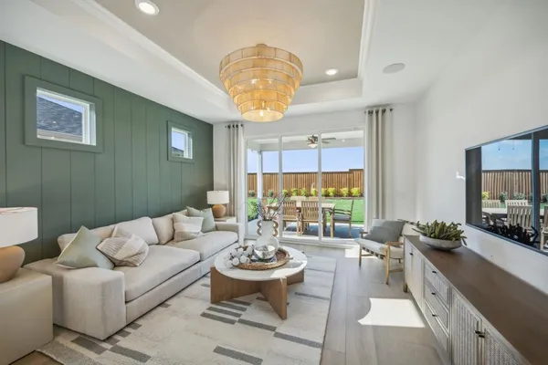 a living room with furniture a flat screen tv and a large window