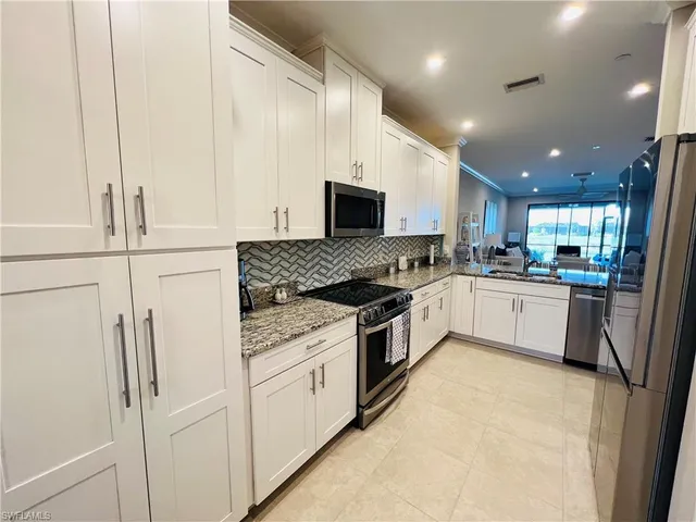 a kitchen with white cabinets and white appliances