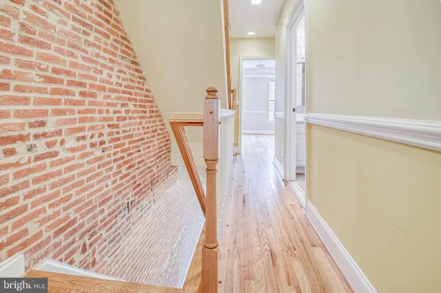 a view of a hallway with wooden floor and staircase