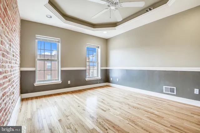 an empty room with wooden floor and windows