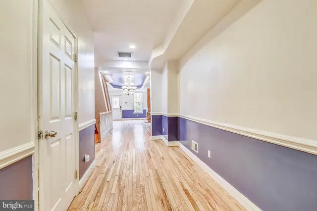 a view of a hallway with wooden floor and staircase
