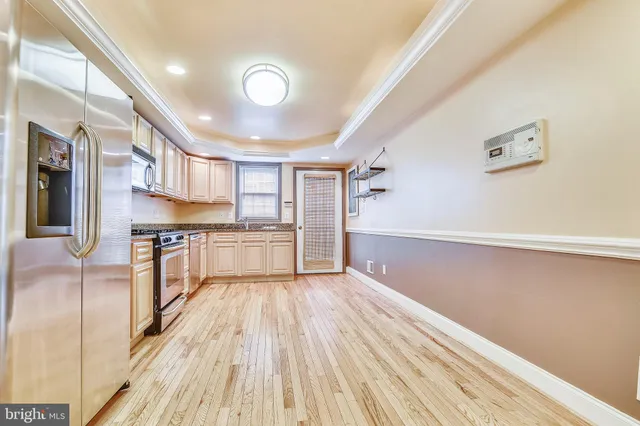 a view of kitchen with stainless steel appliances cabinets and wooden floor