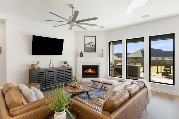 a living room with furniture a flat screen tv and a fireplace