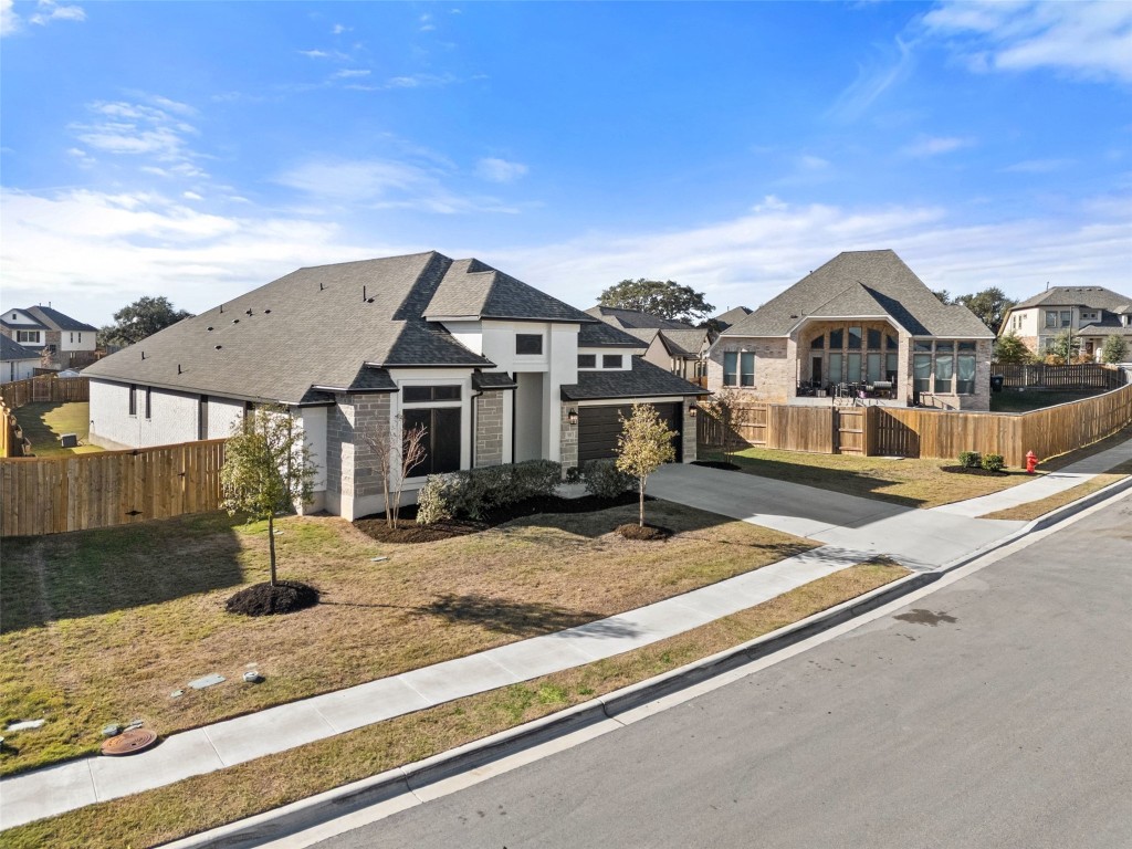 321 Allegheny Way Kyle, TX 78640 - Photo 2 of 40 French country style house with concrete driveway, a shingled roof, a residential view, and stone siding