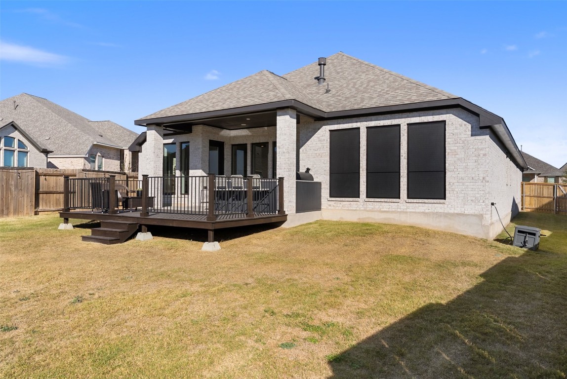 321 Allegheny Way Kyle, TX 78640 - Photo 35 of 40 Rear view of house with a fenced backyard, roof with shingles, brick siding, and a deck