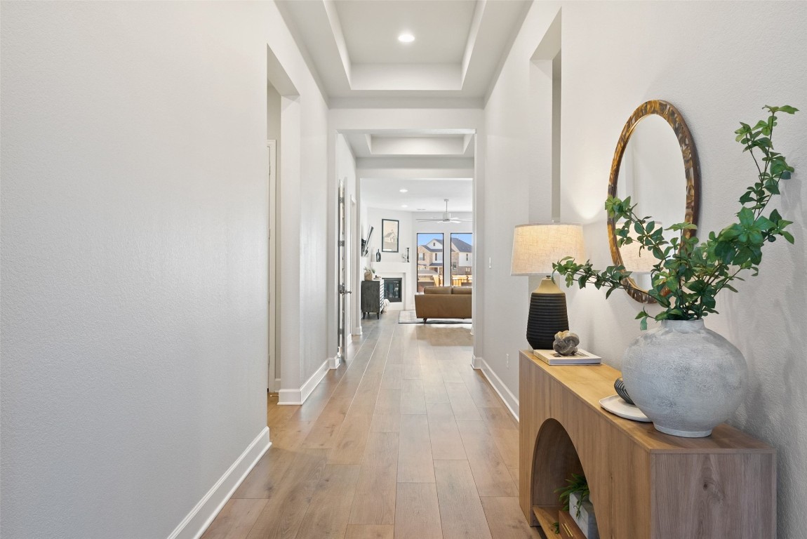 321 Allegheny Way Kyle, TX 78640 - Photo 5 of 40 Corridor featuring light wood-style floors and a tray ceiling