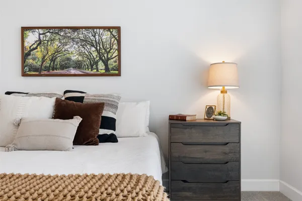 a bedroom with a bed and a painting on the wall