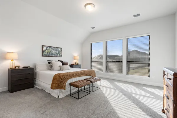 a spacious bedroom with a bed and a large window