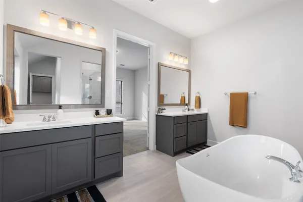 a bathroom with a tub sink and mirror