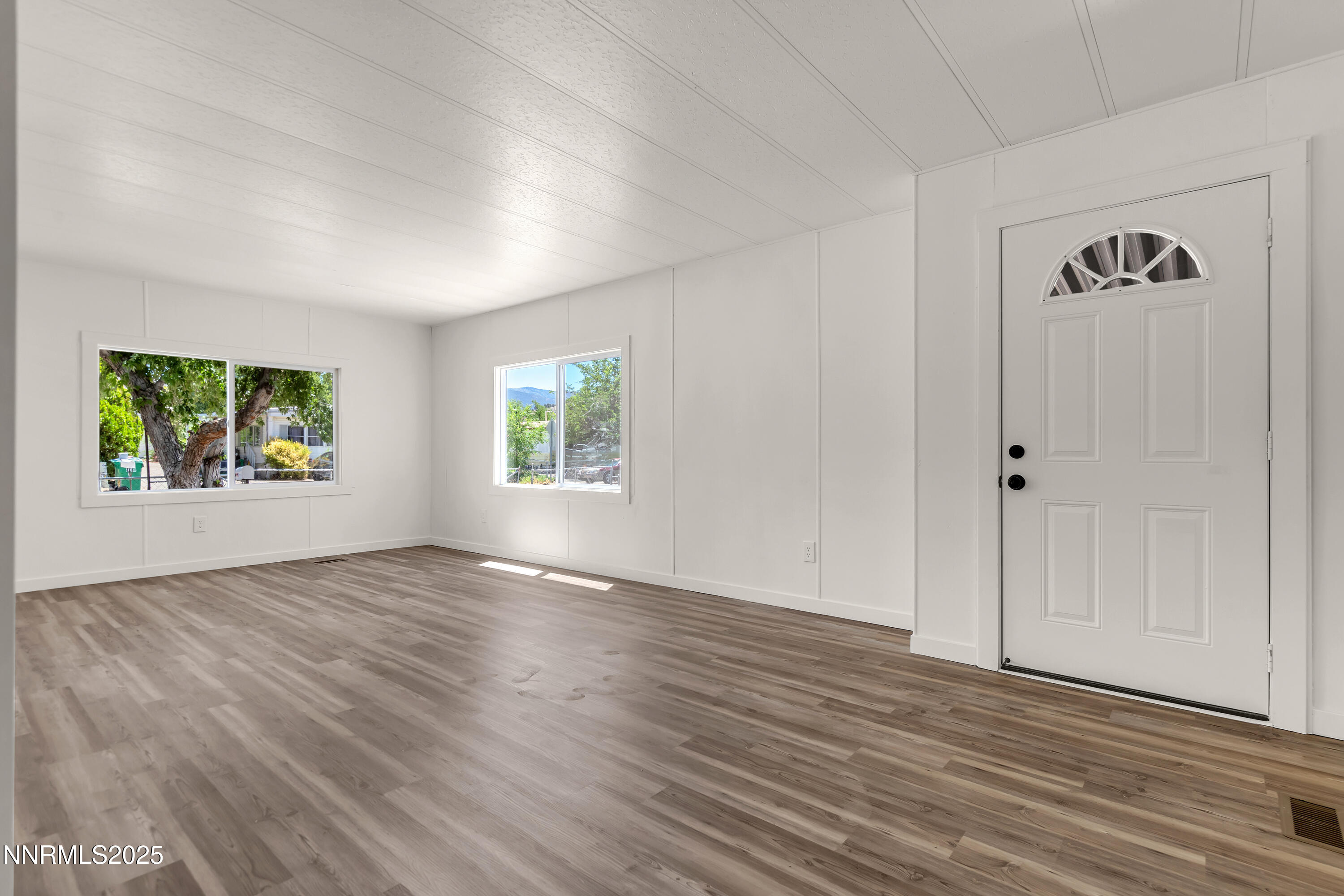 16385 Rhyolite Circle Reno, NV 89521 - Photo 4 of 50 an empty room with window and wooden floor
