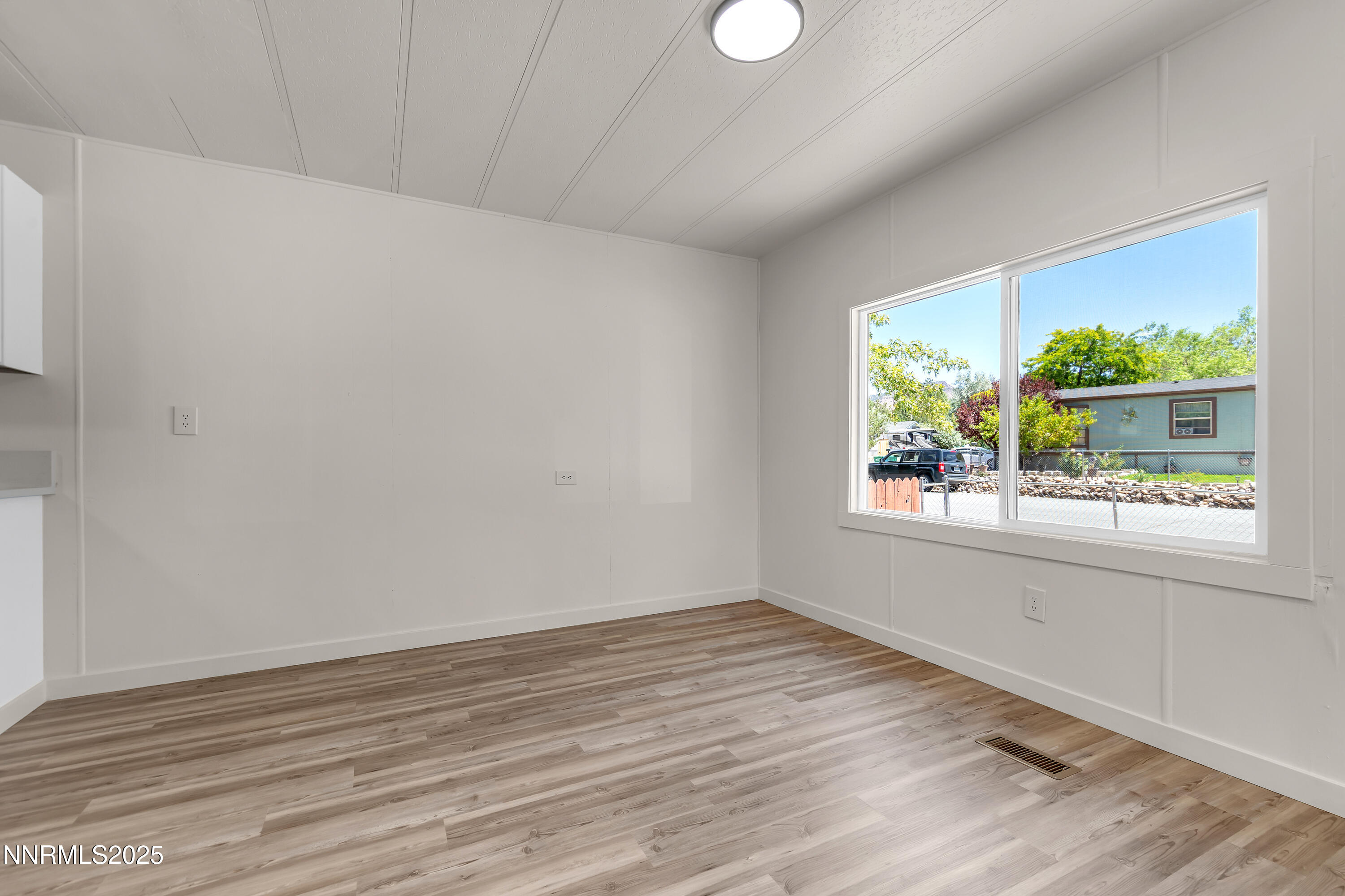 16385 Rhyolite Circle Reno, NV 89521 - Photo 8 of 50 a view of an empty room with wooden floor and a window