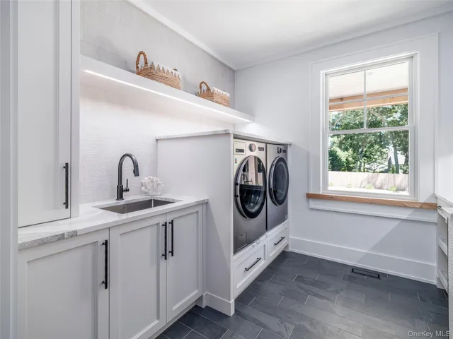 a bathroom with a sink a toilet and a large mirror