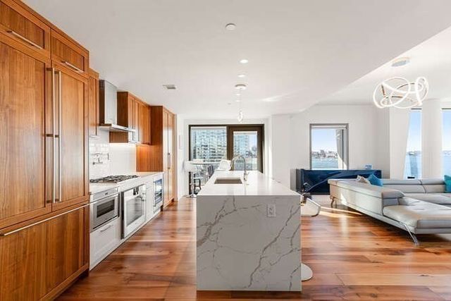 a living room with stainless steel appliances granite countertop furniture and a kitchen view