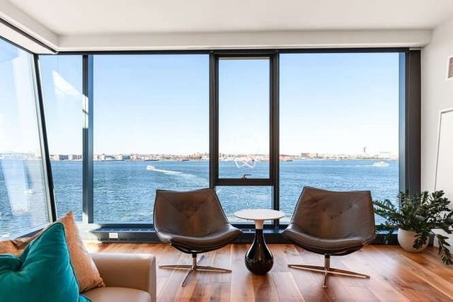 a view of a living room with furniture and floor to ceiling window