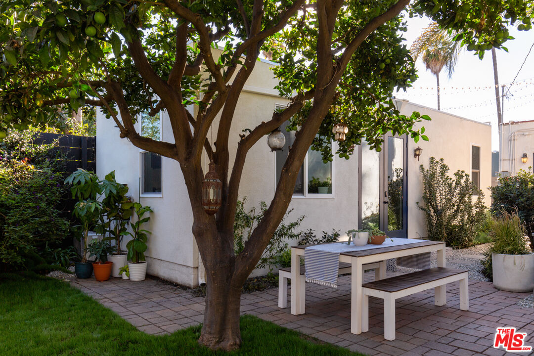 3420 Buckingham Road Los Angeles, CA 90016 - Photo 28 of 41 a view of a patio with table and chairs potted plants and large tree