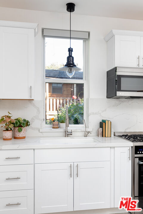 3420 Buckingham Road Los Angeles, CA 90016 - Photo 30 of 41 a kitchen with a stove a sink and a microwave