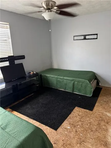 a bedroom with a bed and a ceiling fan