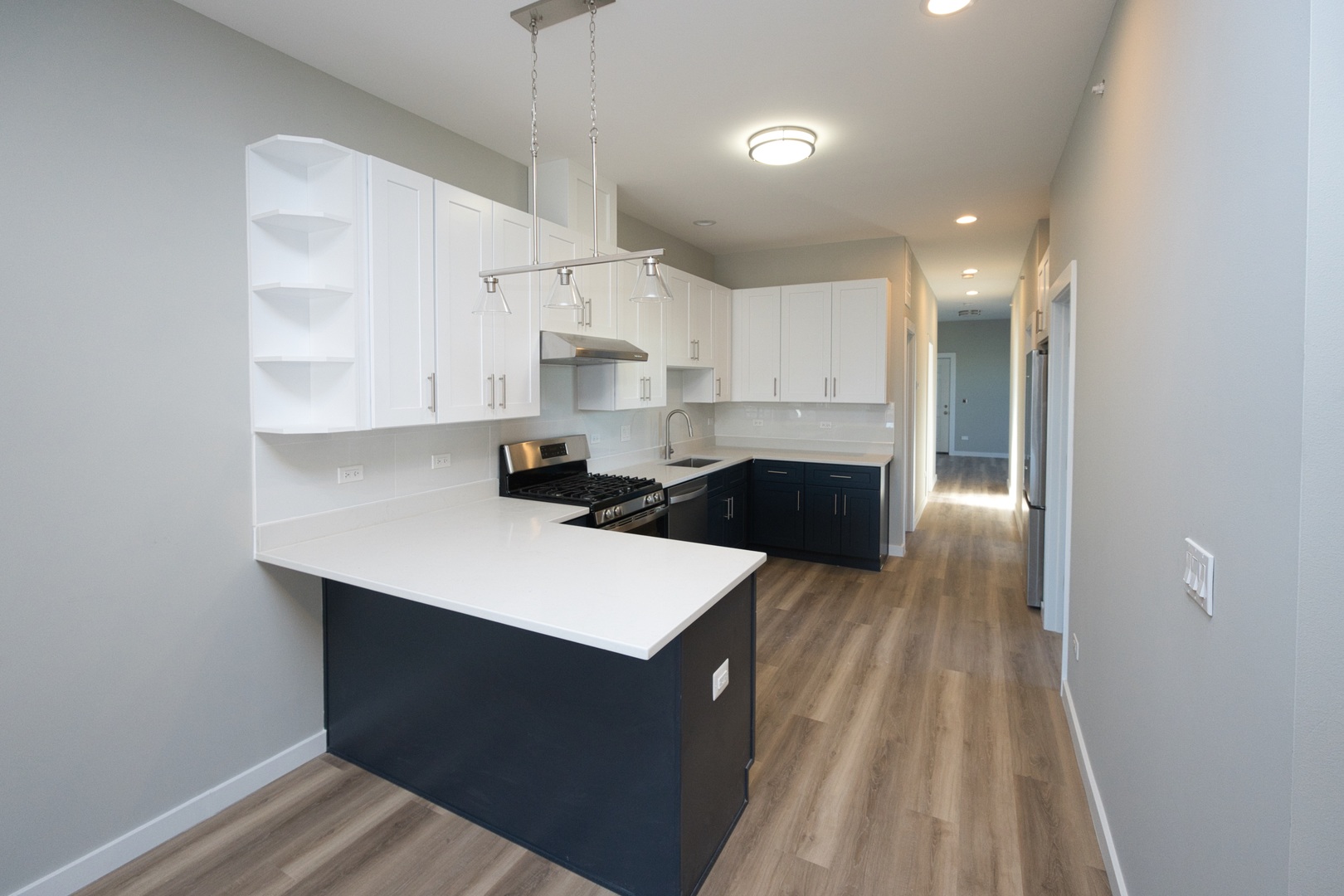 3122 South Morgan Street Chicago, IL 60608 - Photo 19 of 33 a kitchen with kitchen island a sink dishwasher a stove and white cabinets with wooden floor