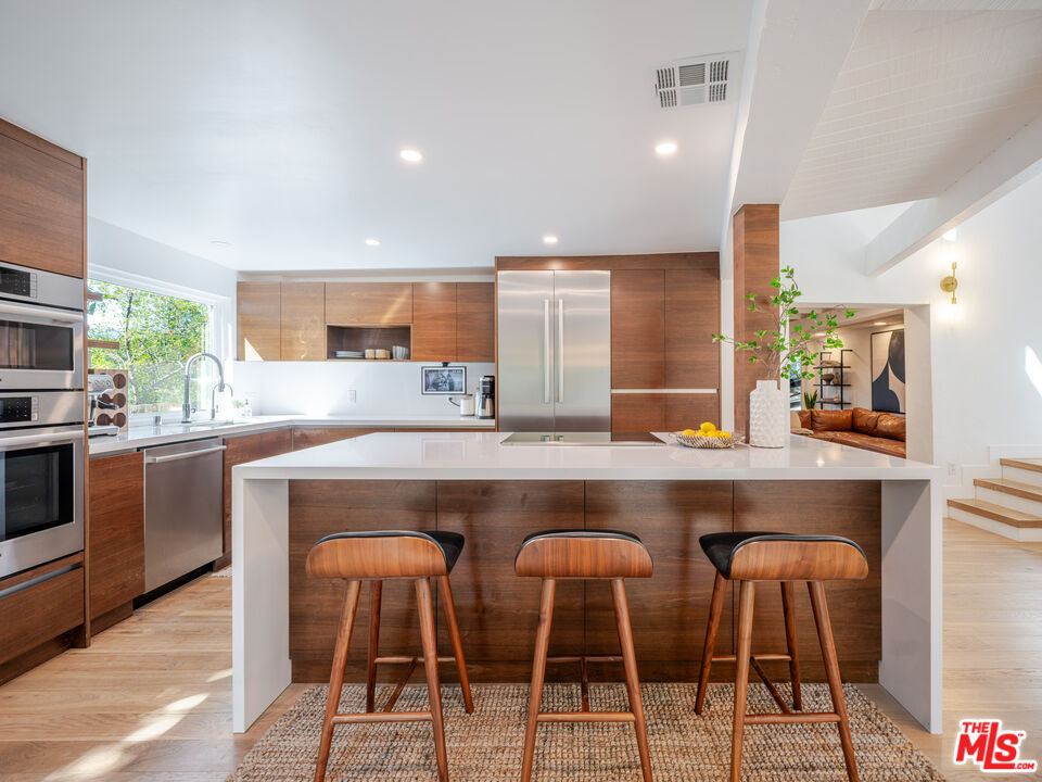20922 Keller Road Topanga, CA 90290 - Photo 12 of 49 a kitchen with cabinets table and chairs