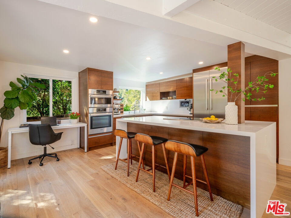 20922 Keller Road Topanga, CA 90290 - Photo 13 of 49 a kitchen with stainless steel appliances kitchen island granite countertop wooden cabinets a dining table and chairs