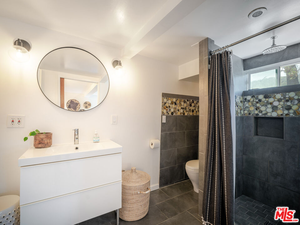 20922 Keller Road Topanga, CA 90290 - Photo 23 of 49 a bathroom with a sink a mirror a toilet and shower