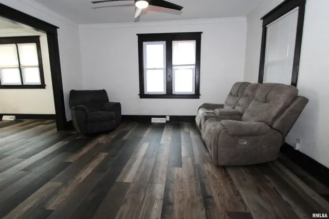 a living room with furniture and a hard wood floor