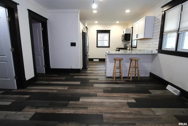 a living room with kitchen island granite countertop furniture and a fireplace