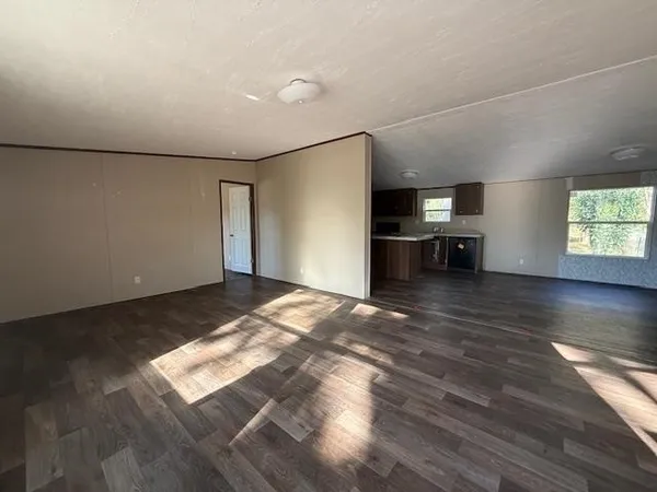 a view of empty room with wooden floor and window