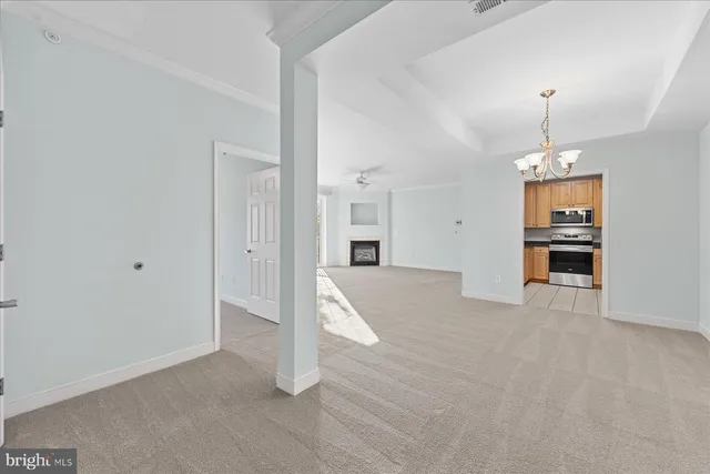 a view of empty room with a kitchen
