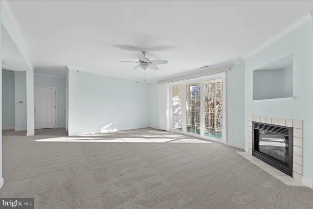 a view of an empty room with a fireplace and a window