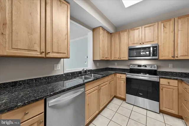 a kitchen with granite countertop a stove top oven microwave and cabinets