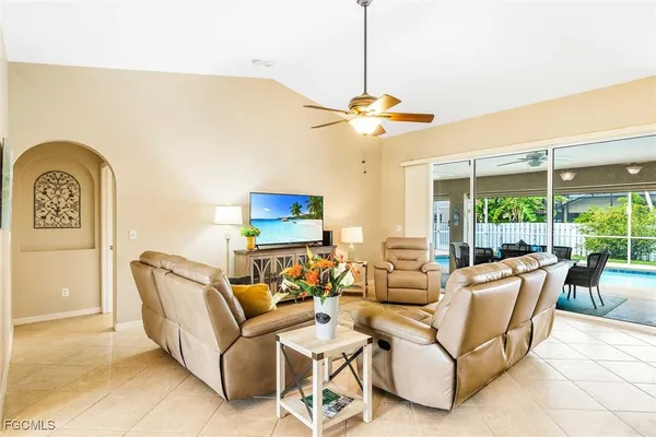 a living room with furniture a ceiling fan and a window