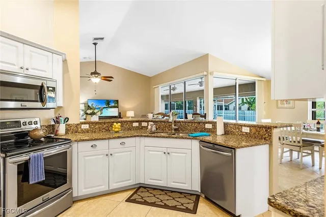 a kitchen with granite countertop a sink stove and cabinets