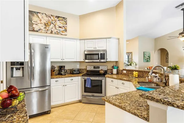 a kitchen with stainless steel appliances granite countertop a refrigerator stove microwave and sink