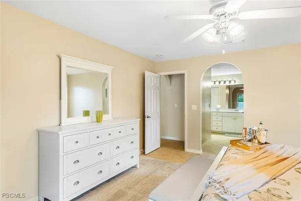 a bedroom with a bed and a mirror on the dresser