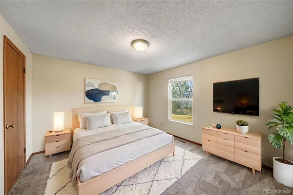 a bedroom with a bed and a flat screen tv