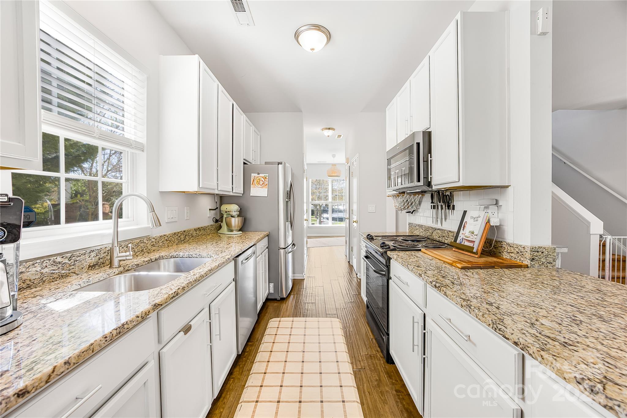 1214 Rising Oak Drive Charlotte, NC 28206 - Photo 11 of 38 a large kitchen with granite countertop a sink and dishwasher wooden cabinets with a granite countertops