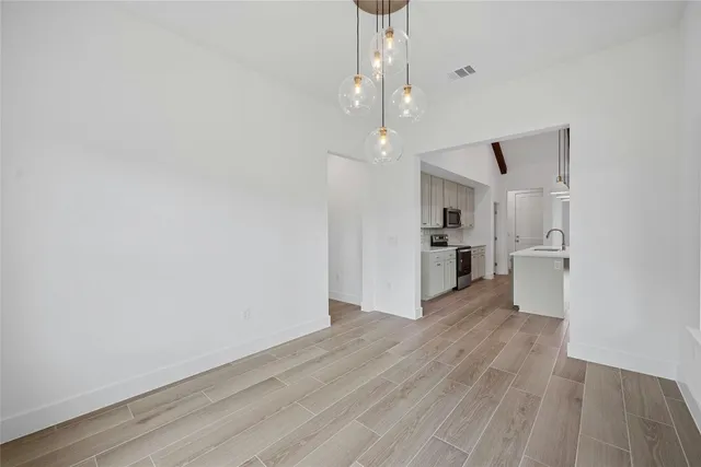 a view of a kitchen with wooden floor and a window
