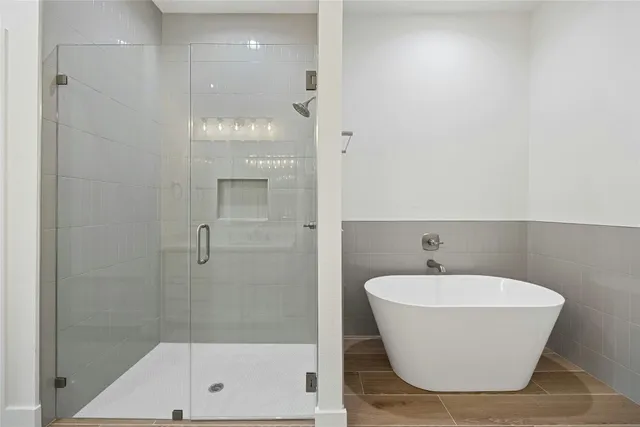 a bathroom with a white tub shower and sink