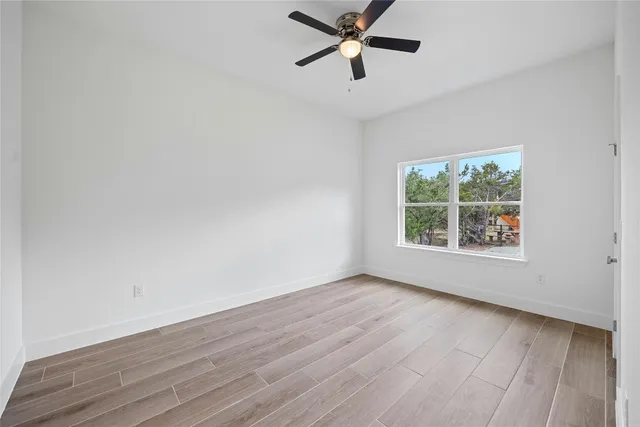 a view of a big room with wooden floor and windows