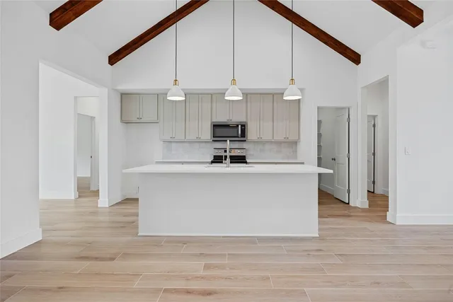 a view of kitchen with stainless steel appliances granite countertop a stove a sink and a refrigerator