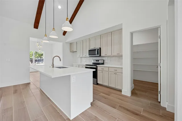a kitchen with a refrigerator and a stove top oven