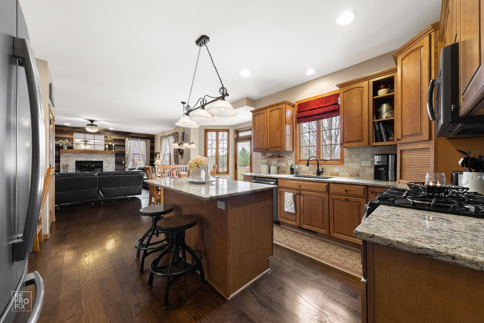 355 Meadow View Burlington, IL 60109 - Photo 6 of 37 a kitchen with stainless steel appliances granite countertop a refrigerator a sink dishwasher a stove and a dining table with wooden floor