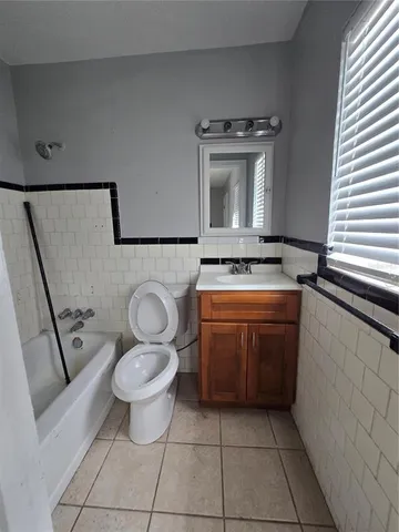 a bathroom with a stove a toilet a sink and mirror