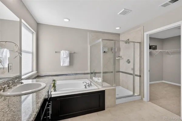 a bathroom with a tub sink shower and mirror