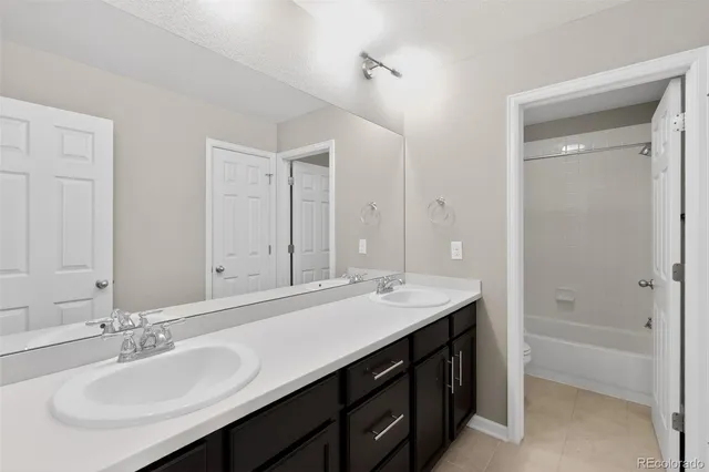 a bathroom with a sink double vanity granite tub shower and a mirror
