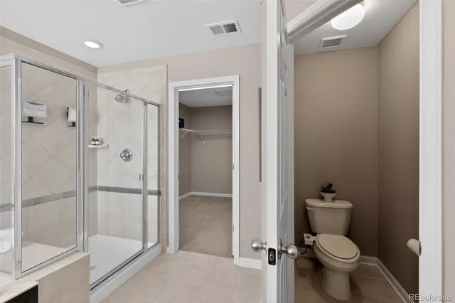 a bathroom with a granite countertop toilet a sink and shower