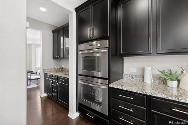 a kitchen with granite countertop cabinets stainless steel appliances and wooden floor
