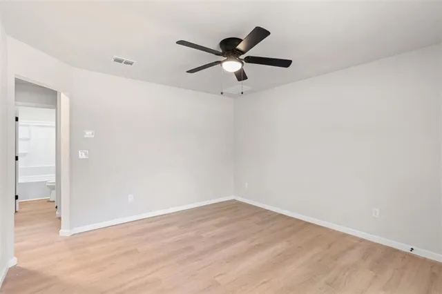 a view of a big room with wooden floor and a ceiling fan
